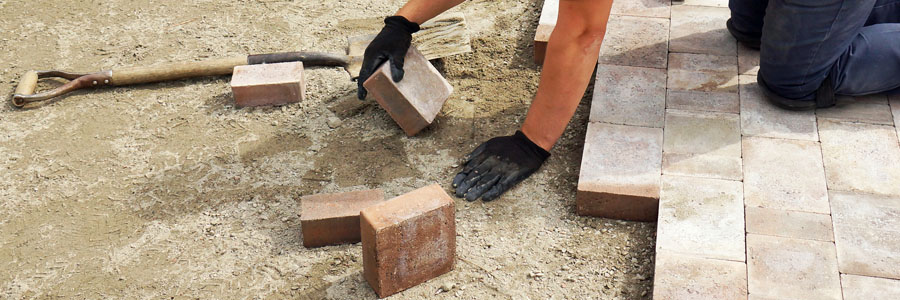 Variety of paver stones laid in a decorative pattern for a patio walkway installation